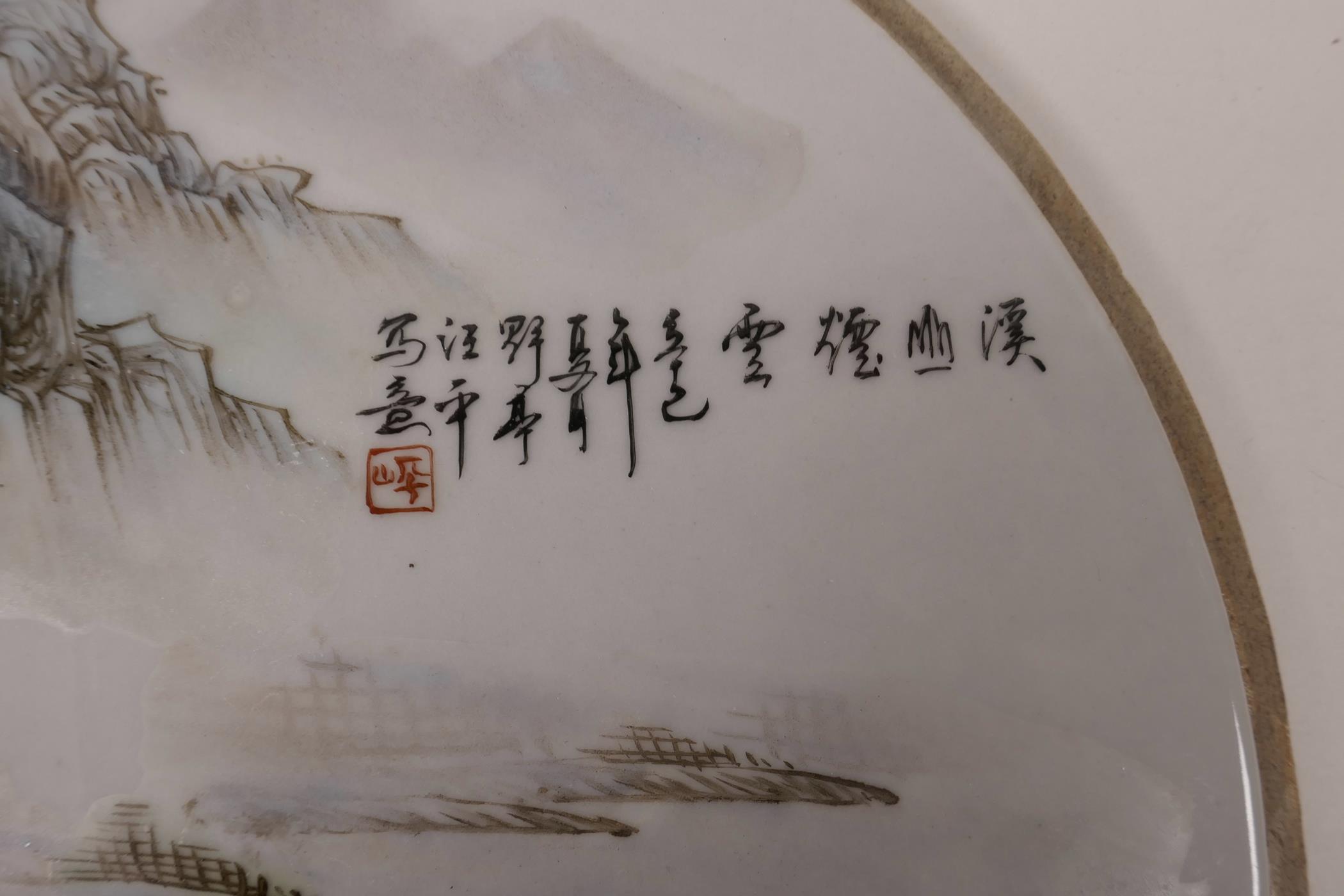 A Chinese famille verte porcelain plaque decorated with a river landscape, 10½" diameter - Image 2 of 3