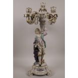 A Continental porcelain five branch candelabra, in the form of a dandy bearing a cornucopia, 19"