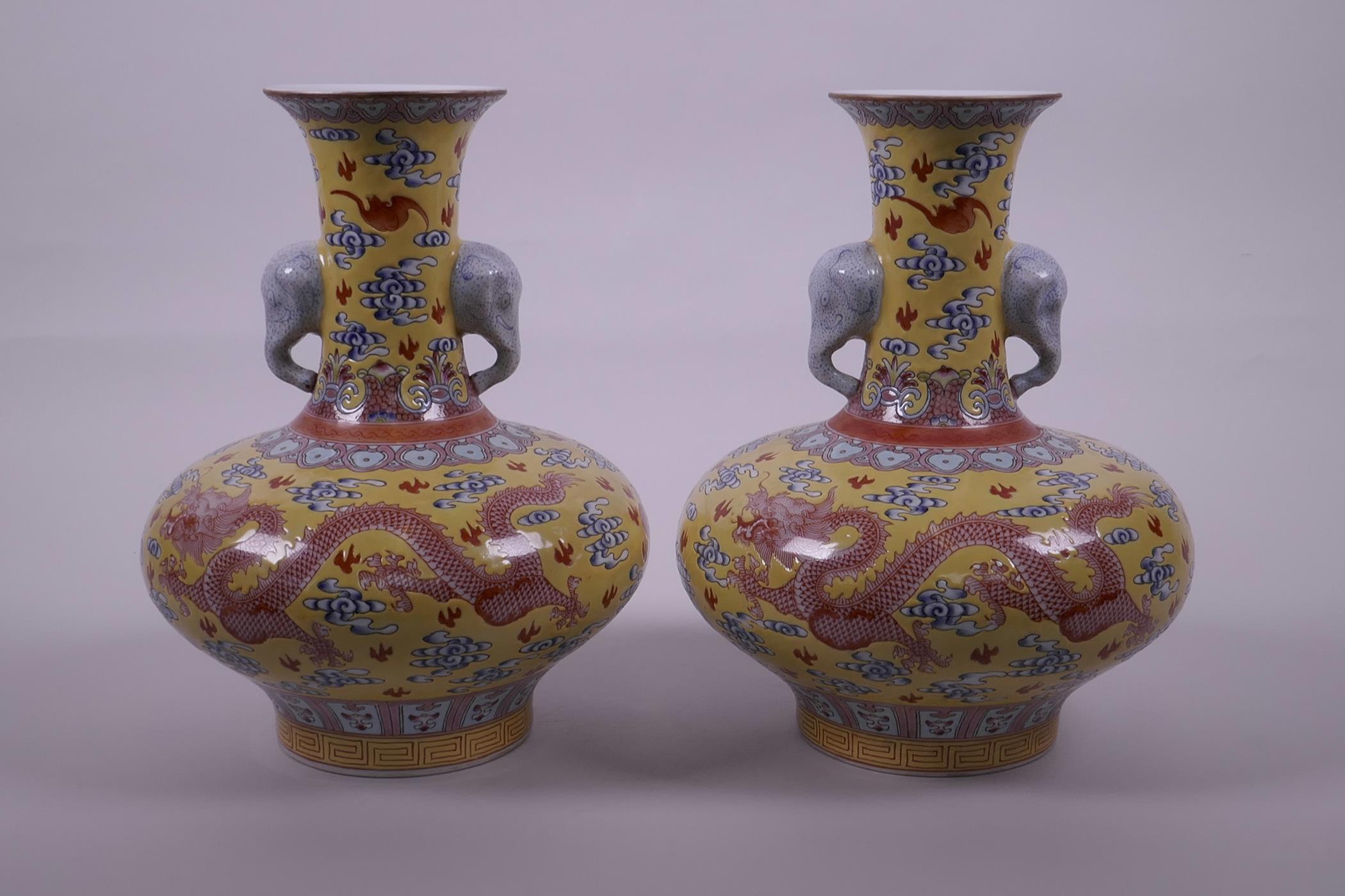 A pair of Chinese yellow ground vases with two elephant head handles and iron red dragon decoration,