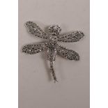 A white metal and marcasite set brooch in the form of a dragonfly with articulated wings, 2"