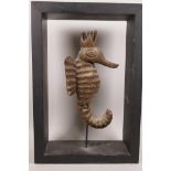 A carved wood figurine of a seahorse mounted in a wooden frame, 11" x 16" overall