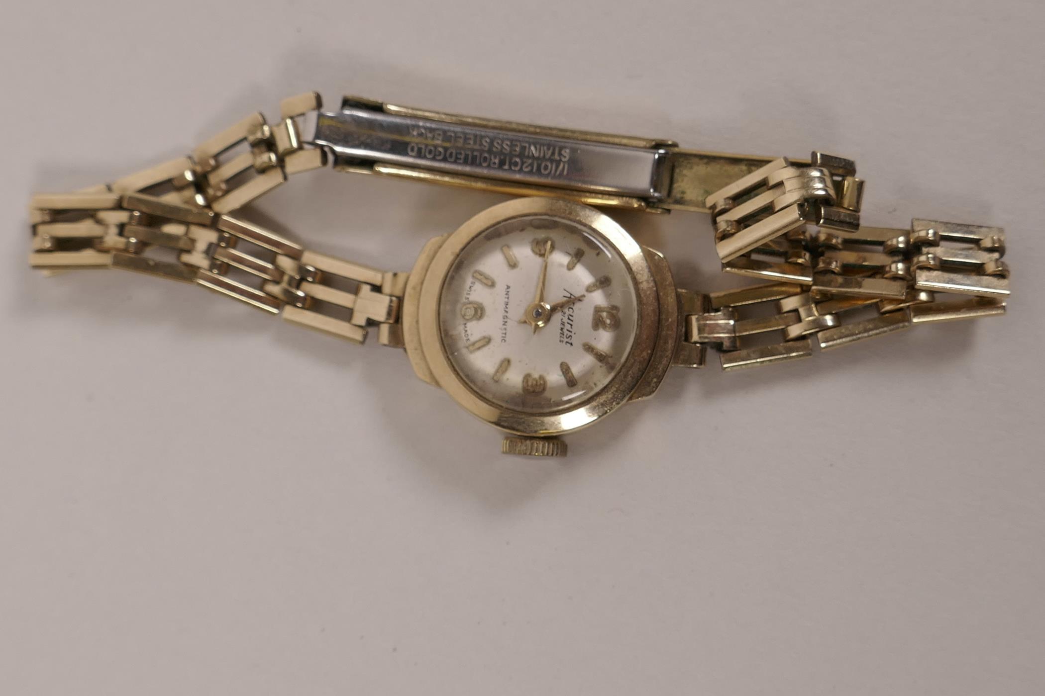 A ladies Accurist 9ct gold cased wristwatch on rolled gold bracelet