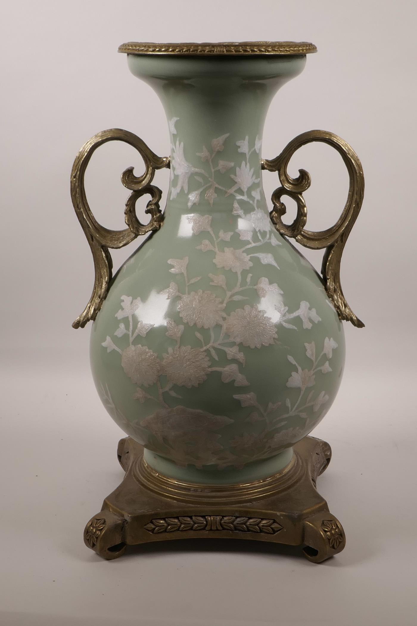A Chinese celadon ground porcelain vase with later applied ormolu mounts and handles, and white