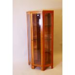 A contemporary walnut corner display cabinet, with bevelled glass, fitted with illumination, 22" x