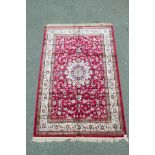 A red ground Kashmir carpet with a Shabaz medallion design, 60" x 90"