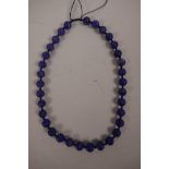 A string of lapis lazuli beads decorated with carved auspicious symbols, 18" long