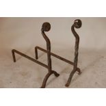 A pair of antique wrought iron fire dogs, 26½" high, 22" deep