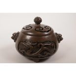 A Chinese bronze censer and lid on tripod feet with two lion mask handles and stylised dragon