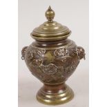A small Japanese copper on bronze urn and cover with two lion mask ring handles, the body chased and