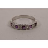An 18ct white gold, nine stone, ruby and diamond set ring, approximate size 'K'