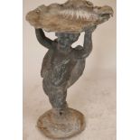 A lead garden bird bath in the form of a large shell supported by a winged cherub, 25" high, A/F