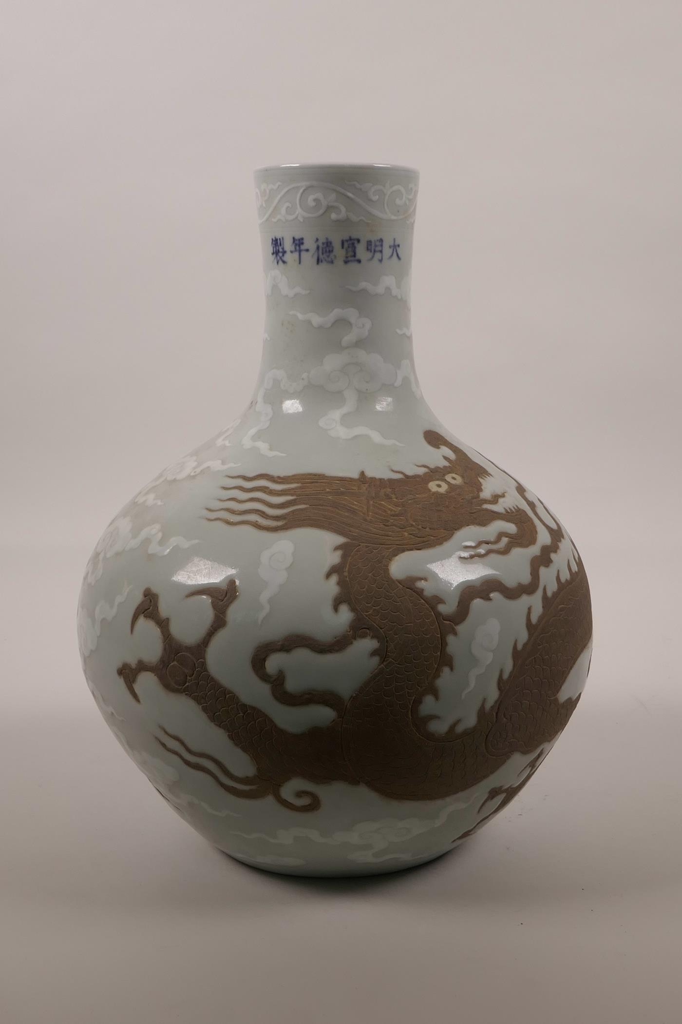 A Chinese celadon glazed pottery vase with chased dragon decoration, 6 character mark to neck,