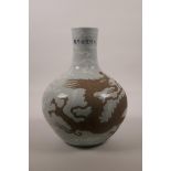 A Chinese celadon glazed pottery vase with chased dragon decoration, 6 character mark to neck,