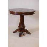 An oak centre table with gilt tooled leather inset top, raised on shaped column and shaped supports,