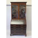 A George III mahogany bookcase, the astragal glazed top on a fall front base with fitted interior