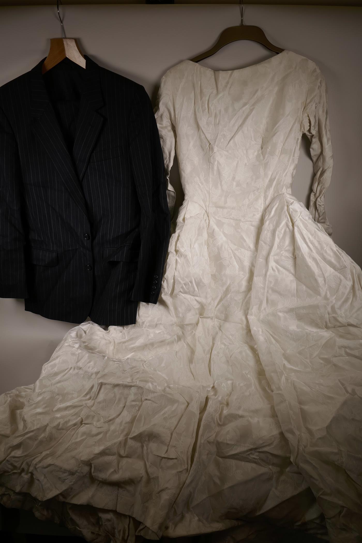 A white satin wedding dress from Marshall and Snelgrove, and a Christian Dior blue pin striped suit