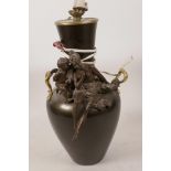 A bronzed table lamp, the two handled vase shaped body with applied decoration of a semi clad lady