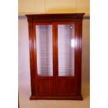 A contemporary walnut two door display cabinet, with moulded frieze and fluted sides, 81" x 53" x