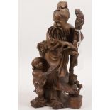 An Oriental rootwood carving of a bearded sage with a small child, 10½" high