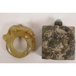 A Chinese carved hardstone thumb ring carved as a mythical beast, 2" diameter, together with a