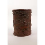 A Chinese bamboo brush pot with carved decoration of figures painting a scroll, 6" high