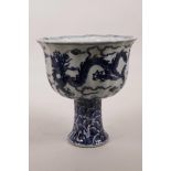 A Chinese blue and white porcelain stem bowl with a lobed rim, ribbed stem and dragon decoration,