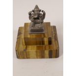 A small white metal figurine of Ganesh mounted on a heavy two piece tiger's eye base, 3" square