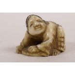 A Japanese ivory netsuke carved as a kneeling man, 1" long