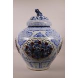 A large Chinese blue and white pottery jar and cover with raised decorative floral panels