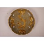 A Chinese celadon dish of lobed form, with applied gilt metal dragon decoration and metal rim, 7½"