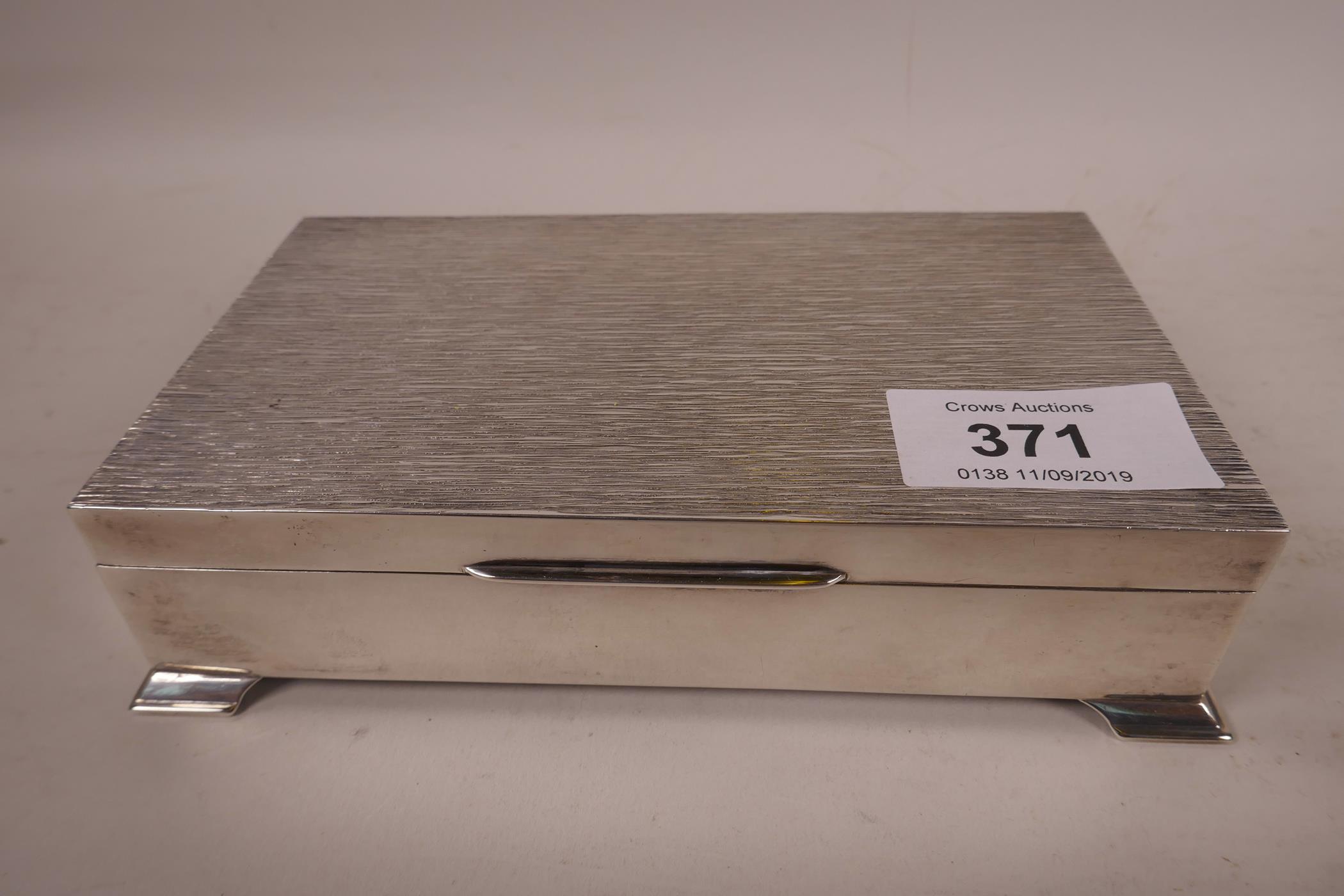 A silver cigarette box, hallmarked Birmingham 1975, 6" long, 3½" wide x ¼" high