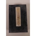 A Chinese silk and hardwood bound book containing white jade tablets with engraved and gilt