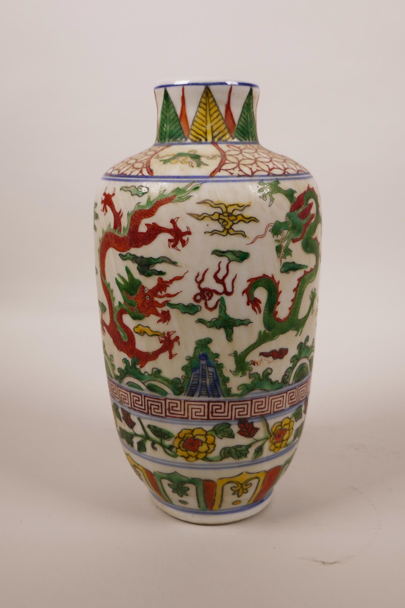 A Chinese wucai porcelain vase decorated with dragons chasing the flaming pearl, 6 character mark to