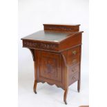 An Edwardian walnut Davenport with pen and letter compartment and rising top over four dummy and