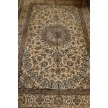 A large Persian Nain hand knotted wool carpet with traditional floral design on a cream ground, 145"