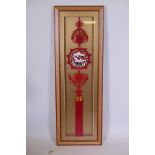 A Chinese red knotted tassel wall hanging pendant with an enamelled copper plaque decorated with