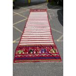 A large Uzbek Kelim carpet with red and cream banded decoration, 255" x 81"