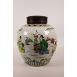 A Chinese famille verte pottery ginger jar with a pierced hardwood cover, decorated with figures