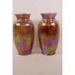 A pair of Loetz style iridescent glass vases with swirled decoration, 9" high