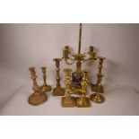 Seven various C19th and other brass candlesticks and a brass column table lamp, A/F, 17" high