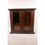 A stained beech smoker's cabinet with two glazed doors revealing pipe rack and five internal