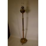 A C19th telescopic brass column standard oil lamp on circular base with paw feet, the lamp with a