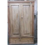 A C19th Continental stripped pine armoire with two panelled doors over a single drawer, lacks