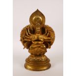 A Sino-Tibetan gilt bronze of a many armed deity seated on a lotus throne, indistinct mark to