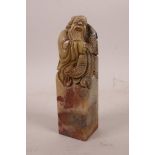 A Chinese chicken blood soapstone seal with carved decoration of a fisherman, 4½" high