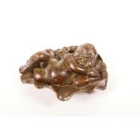 A small Chinese bronze of a child sleeping on a lily pond, impressed seal mark to base, 2½" long