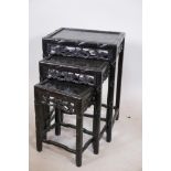 A nest of three Chinese carved and ebonised hardwood occasional tables, with bamboo decoration,