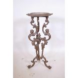 A cast iron jardiniere stand on a triform base with cherubic decoration, A/F, 32" high