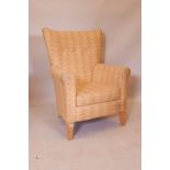 A contemporary shaped back armchair, raised on tapering supports