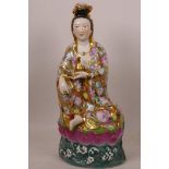 A Chinese porcelain figurine of Quan Yin seated on a lotus throne, painted in bright enamels, 12"